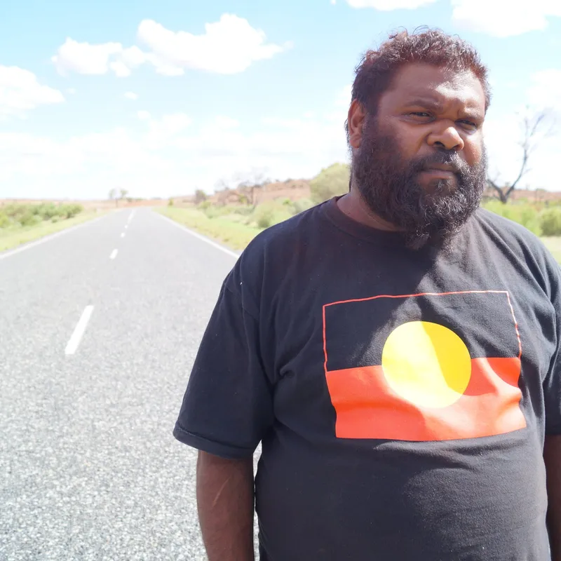 Broadcaster standing on the road outside the community
